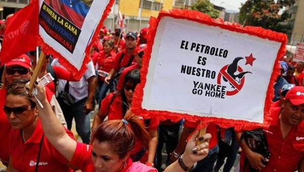 Workers of state-run oil company PDVSA take part in a 2015 rally against U.S. imperialism. The placard reads: 