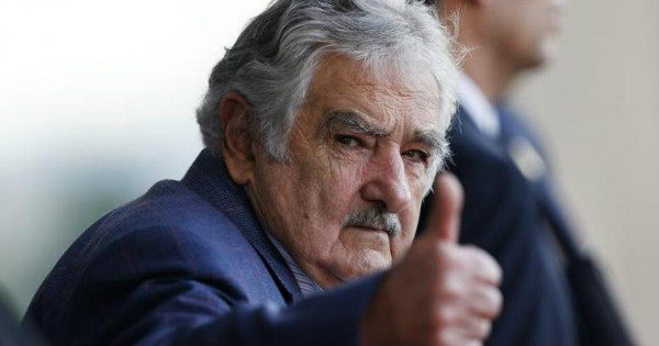 Uruguay's President Jose Mujica waves as he leaves Brazil's Itamaraty Palce after the 6th BRICS summit.