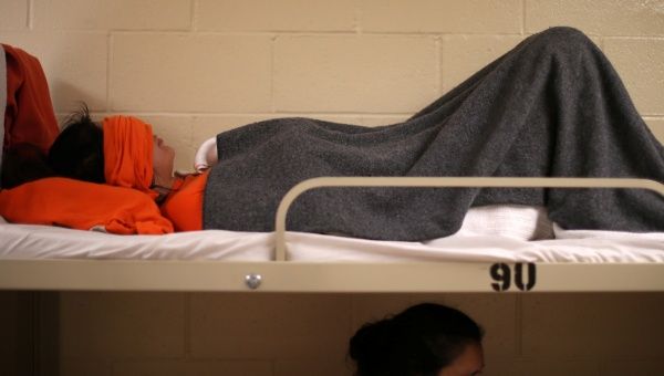 A woman lies on a bed in a dormitory at the Adelanto immigration detention center, which is run by the Geo Group Inc., in Adelanto, California, April 13, 2017. 