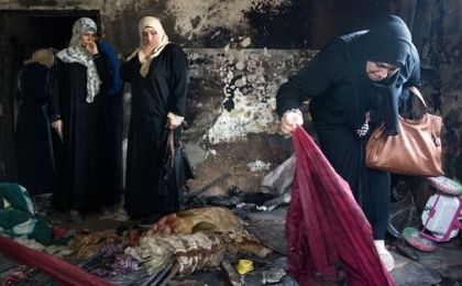Palestinian women look at the damage at the Dawabsha family's home in the West Bank village of Duma on Aug. 4, 2015, after it was burned by Jewish extremists.