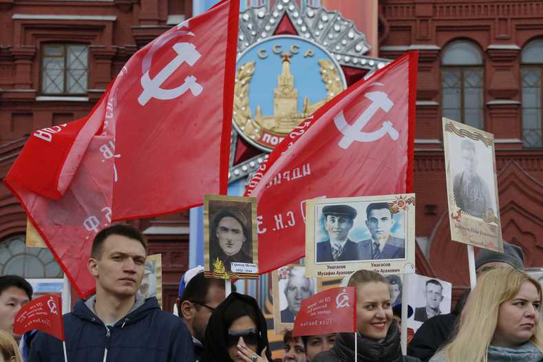 People hold flags and pictures of World War Two soldiers before the Immortal Regiment march during the Victory Day celebrations, marking the 72nd anniversary of the victory over Nazi Germany in World War Two, at Red Square in Moscow, Russia, May 9, 2017. 