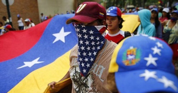 A Venezuelan opposition protester wears a U.S. flag bandanna around his face.