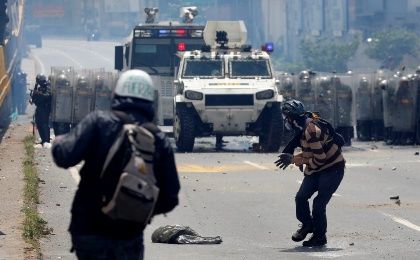 Hooded opposition protesters attacking Venezuelan police officers with Molotov cocktails and stones