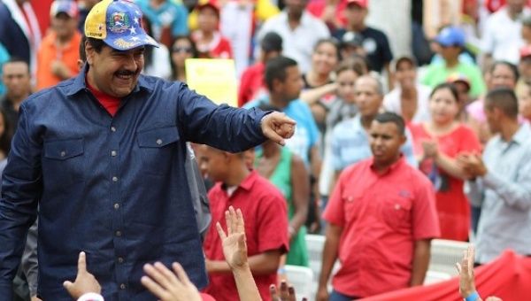 Venezuelan President Nicolas Maduro(L) greets supporters during a rally at the Miraflores presidential palace in Caracas, on May 11, 2016.