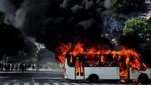 A group of hooded men in Caracas took a public bus driver hostage on Saturday and then set his vehicle on fire.
