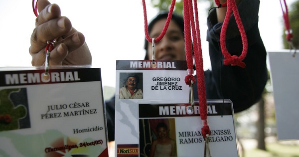 A woman hangs media accreditations with the names of journalists killed while covering the news in Mexico.