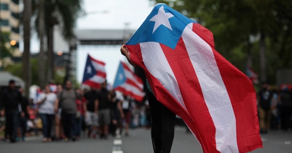 A person carries a Puerto Rican national flag in San Juan during a protest against the government's austerity measures.