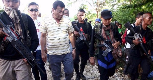 President of the Philippines, Rodrigo Duterte, walks with rebels from the New People's Army, or NPA.