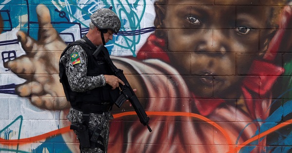 A Brazilian policeman patrols the streets near the Chapadao favela complex during a security operation on an effort to crack down on crime in Rio de Janeiro.