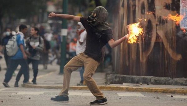 A right-wing protester hurls a Molotov cocktail as violent opposition protests continue into their seventh week.