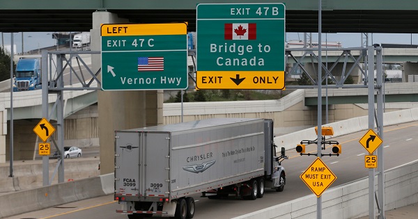 Semi trucks headed for Windsor, Ontario, exit onto the lane towards the Ambassador bridge in Detroit, Michigan, April 26, 2017.