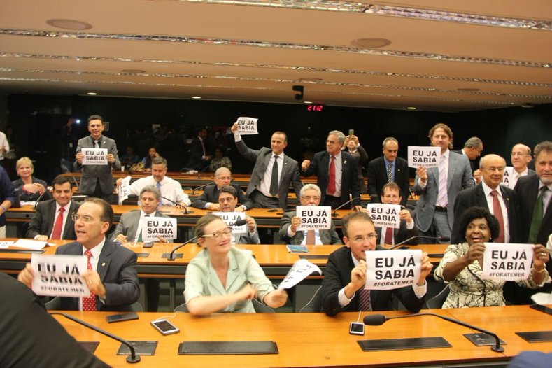 Lawmakers in Brazil's lower house hold signs reading 