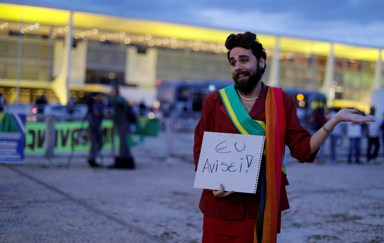 A demonstrator dressed as Brazil's former President Dilma Rousseff gestures during a protest against Brazil's President Michel Temer in front of the Planalto Palace in Brasilia, Brazil, May 18, 2017. The sign reads: 