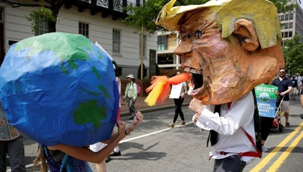 Protesters dressed as the earth and U.S. President Donald Trump pretend to fight during the Peoples Climate March near the White House in Washington, U.S., April 29, 2017. 
