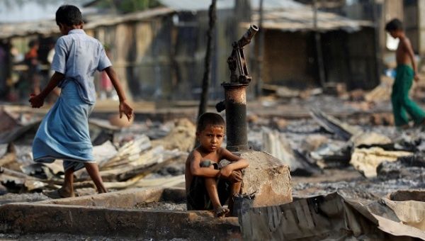 A boy sits in a burnt area after fire destroyed shelters at a camp for internally displaced Rohingya Muslims in Rakhine State, Myanmar, on May 3, 2016. 