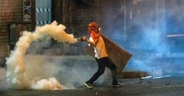 A demonstrator clashes with members of the National Bolivarian Police during a protest against the Venezuelan government.