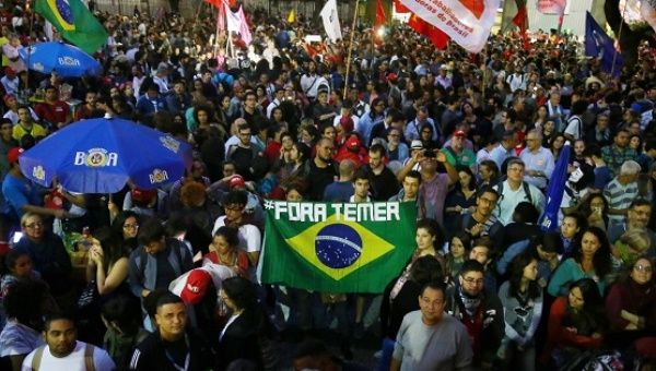 Demonstrators carry a Brazilian national flag as they attend a protest against Brazil's President Michel Temer in Rio de Janeiro.