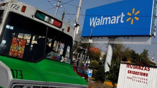 A bus drives past a Wal-Mart sign in Mexico City, Dec. 18, 2012.