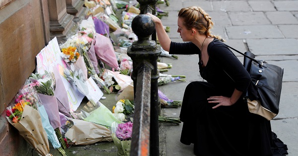 A woman lays flowers for the victims of the Manchester Arena attack, in central Manchester, Britain May 23, 2017.