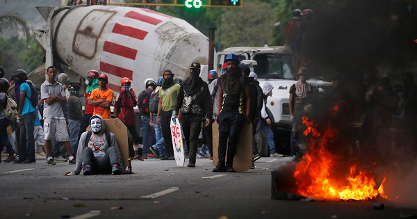 Demonstrators stand near a truck as they use it as a barricade during anti-government protests in Caracas, Venezuela.
