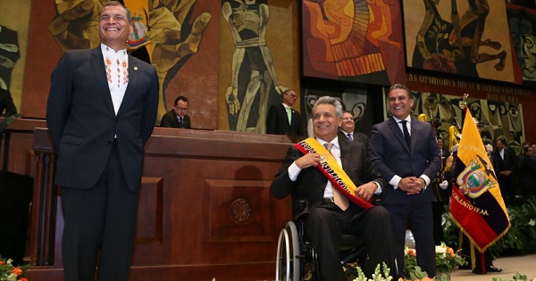 Rafael Correa stands next to President Lenin Moreno after handing him the presidential sash as National Assembly head Jose Serrano looks on.