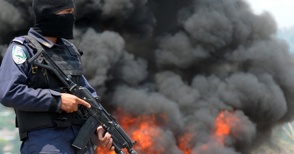 A police officer stands guard as nearly 400 kg of cocaine burn in Tegucigalpa, Honduras.