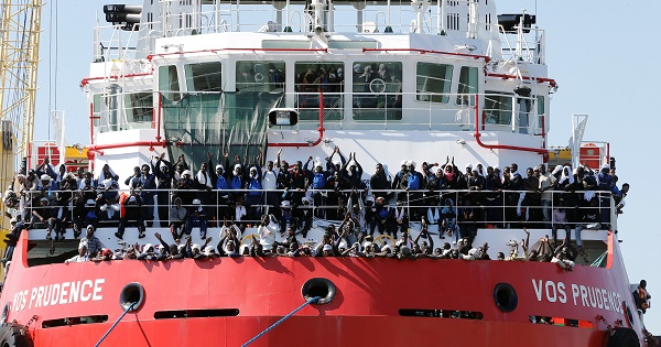 Migrants wait to disembark from 