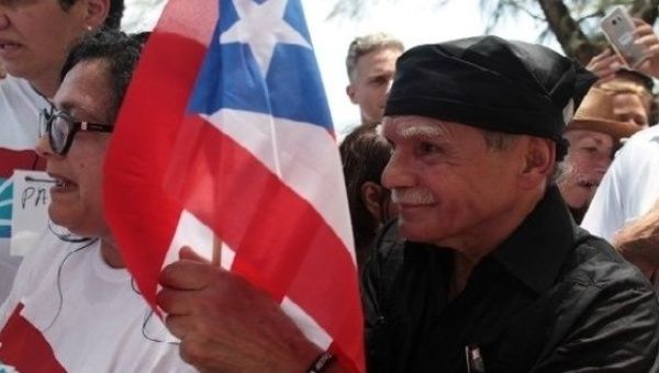 Puerto Rican Oscar Lopez Rivera (C) carries a national flag as he meets with supporters after being released from house arrest in San Juan, Puerto Rico.