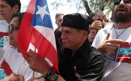 Puerto Rican Oscar Lopez Rivera (C) carries a national flag as he meets with supporters after being released from house arrest May 17, 2017. 