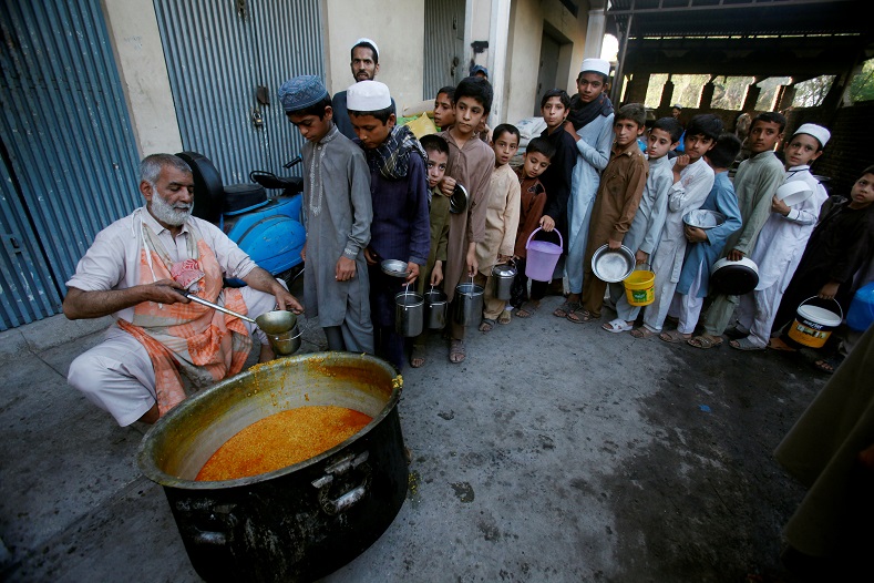 Children wait in line to get free food to break fast, during a Muslim holy month of Ramadan, in Peshawar, Pakistan, June 7, 2017. 