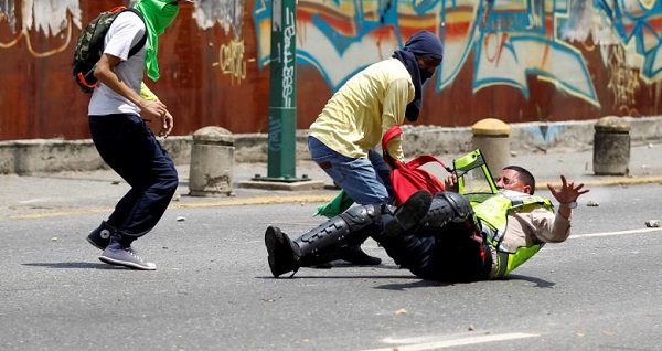 Demonstrators attack a police officer at a rally against Venezuela's President Nicolas Maduro's government.