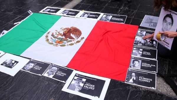 Photos of murdered journalists border the Mexican flag in a protest against the 106 reporters who fell victim to the mass killings in Mexico since 2000.