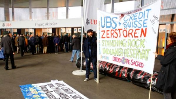  Protesters display a banner to protest against the financing of the Dakota Access oil pipeline by Swiss banks UBS and Credit Suisse as participants arrive ahead of the annual shareholder meeting of Swiss bank UBS in Basel, Switzerland.