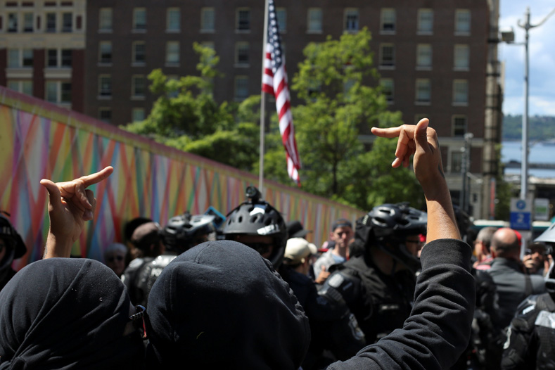 A counter-protester confronts police and anti-Muslim protesters after an 
