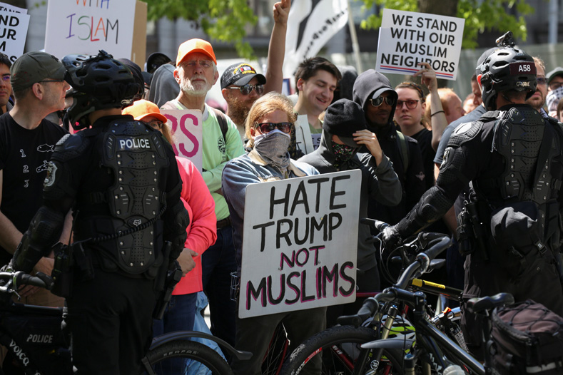 Counter-protesters hold signs outside of an anti-Muslim rally in Seattle, Washington, U.S., June 10, 2017.
