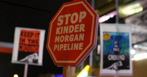 Protesters hold up signs in opposition to Canada's decision to approve Kinder Morgan Inc's pipeline, November 29, 2016.