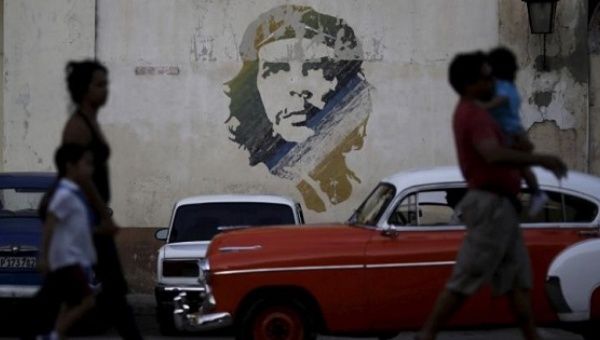People walk past a painting of late revolutionary hero Ernesto ''Che'' Guevara in Havana.