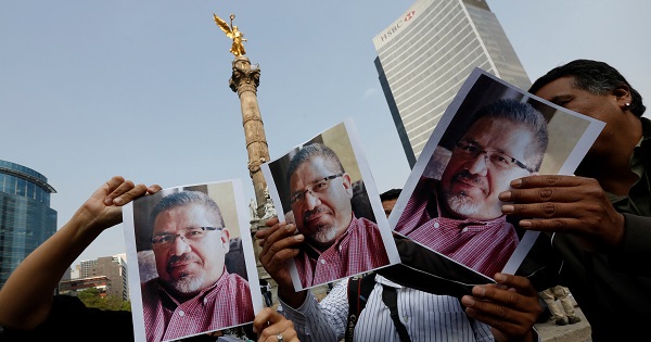 Journalists and photographers hold up pictures of Javier Valdez during a demonstration against his killing in Mexico City, Mexico May 16, 2017.