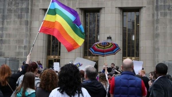 Supporters of same-sex marriage hold a rainbow flag and umbrella outside Jefferson County Courthouse in Birmingham, Alabama, Feb. 9, 2015.