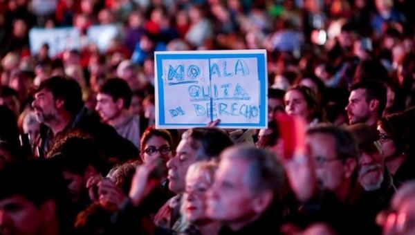 Hundreds of people gathered in Buenos Aires to protest cuts to disability pensions. Sign reads, 