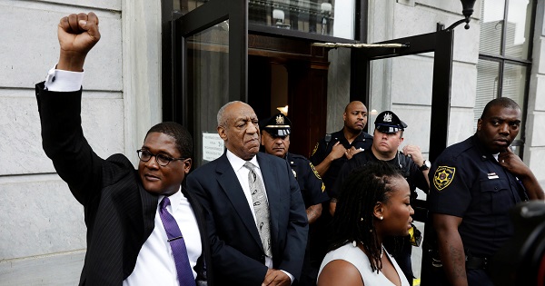 Actor Bill Cosby (C) stands as his publicist Andrew Wyatt raises his fist after a judge declared a mistrial in Cosby's trial in Norristown, Pennsylvania, U.S., June 17, 2017.