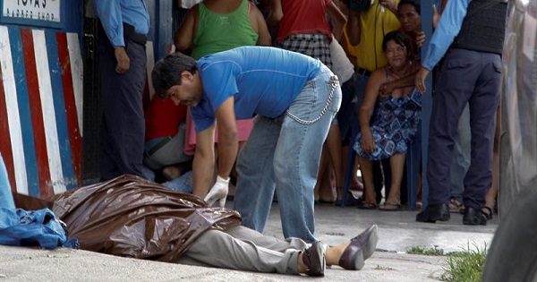 Officials cover the body of Honduran journalist Victor Funes after he was found shot dead in La Ceiba, June 15, 2017.
