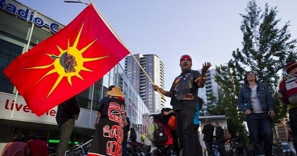 A Mohawk flag is raised at a demonstration against the Northern Gateway pipeline in Vancouver, British Columbia, Canada.