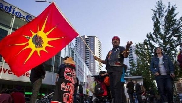 A Mohawk flag is raised at a demonstration against the Northern Gateway pipeline in Vancouver, British Columbia, Canada. 