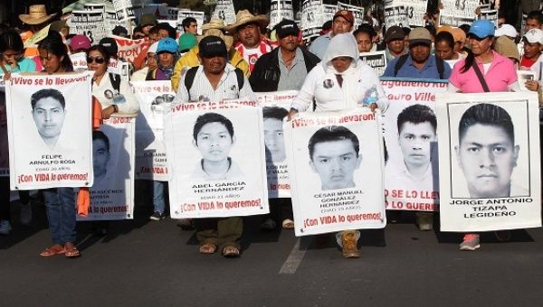 Family members march with pictures of the disappeared 43 Ayotzinapa students