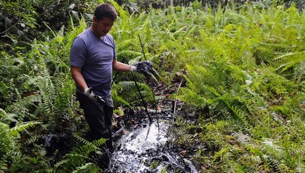 Ecuadorean activist of the Amazonia Defense Front, Donald Moncayo, shows waste of oil at Aguarico 4 oil well, near La Primavera, Sucumbios province, in the Ecuadorean Amazonia.