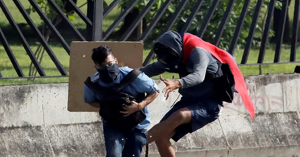 A protester covers David Jose Vallenilla (L), who was fatally injured, outside an air force base during clashes with security forces at a rally near Caracas, Venezuela, June 22, 2017.
