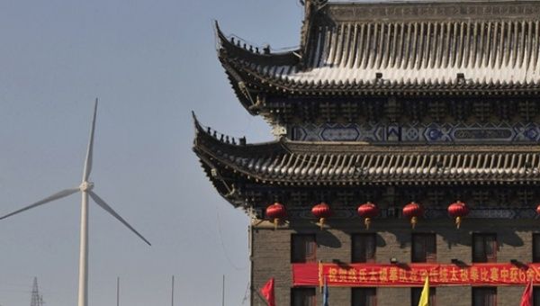 A wind turbine is seen near a gate of the ancient city of Wushu in Diaobingshan. 