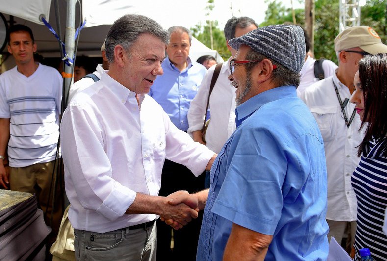 Santos and Timoncheko shake hands before the historic ceremony.