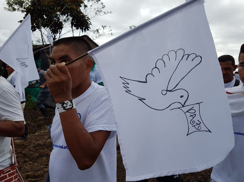 A FARC member holds a sign with the image of a dove, celebrating the historic chapter in the peace agreement between the FARC and the Colombian government.